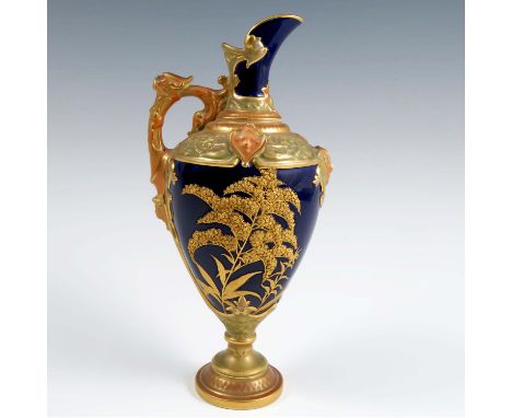 A Royal Worcester ewer, decorated with gilt flowers to a dark blue ground with moulded gilding to the neck, handle and pedest