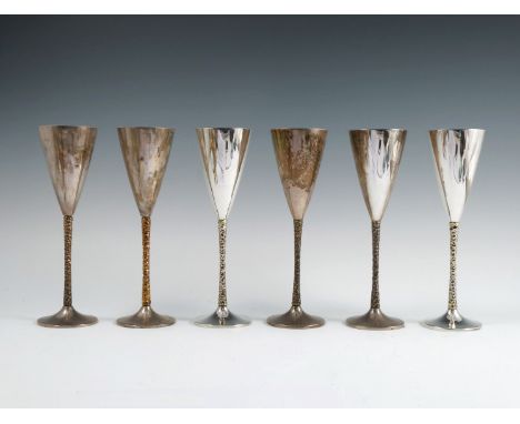 A set of silver champagne flutes, by Stuart Devlin, with gilt bark effect stems, London, numbered 45, 46, 47, 48, 343, 344, a