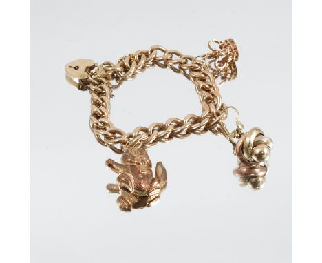 A 9 carat gold bracelet, of solid textured curb links, with three charms attached, 36g gross