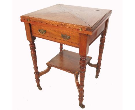 An Edwardian envelope card table, raised on four turned legs, united by a plant shelf, width 21ins, height 30ins