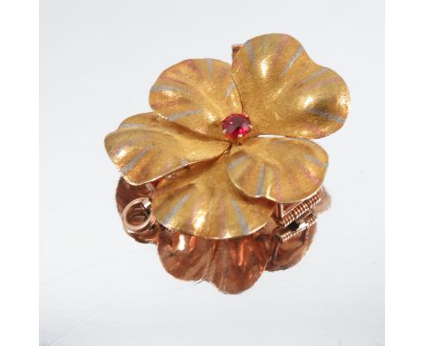 A Victorian gold flower brooch, set with a single garnet, having a hinged pendant loop, width 1.5ins (tests 15ct)