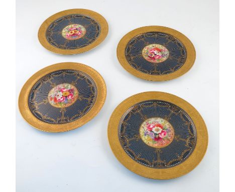 Four Royal Worcester cabinet plates, decorated with flowers by E Phillips, to a deep blue border with gilt decoration, diamet