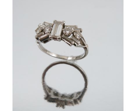A diamond cluster ring, the white mount stamped 'P', the central baguette measuring approximately 5.8mm by 3.9mm by 1.7mm dee