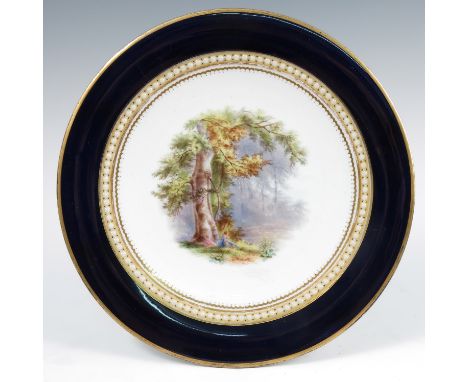 A 19th century Grainger's Worcester cabinet plate, decorated with a landscape of two figures under a tree, to a blue border, 