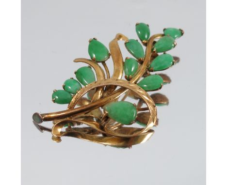 A jade spray brooch, unmarked, with twelve stone set 'leaves', 5cm long, 4.9g gross