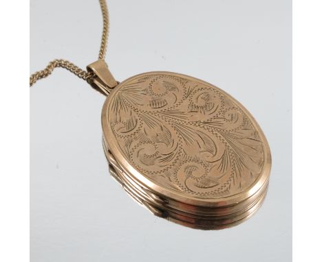 A large 9 carat gold oval locket, 4.3cm long excluding the bale, 17g gross, on a gilt metal chain