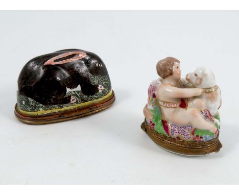 A 19th century relief moulded porcelain pill box, formed as a cherub and sheep, the sash to the cherub marked A Moy Penses, w