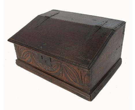 An antique oak bible box, with sloping rising lid, opening to reveal a shelf, and carved to the front, width 21ins, length 11