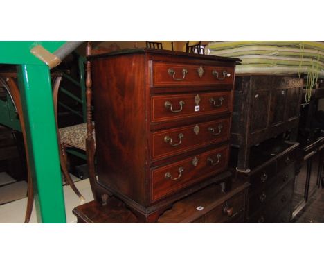 A small 19th century mahogany chest of four long graduated drawers with box wood inlay and brass swan necked handles raised o