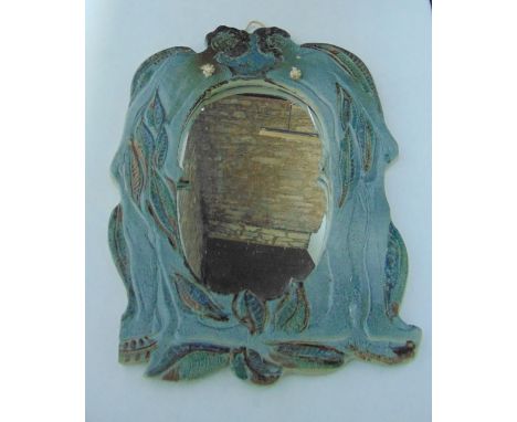 An unusual Studio Pottery mirror frame with incised and painted decoration of a pair of stylised figures amongst leaves in a 