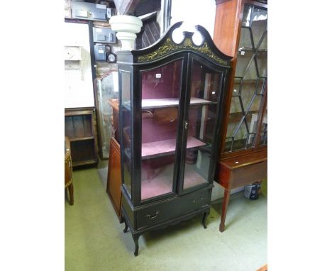 An Edwardian freestanding ebonised display cabinet with broken swan neck architectural pediment over a pair of threequarter l