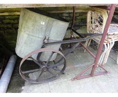 A vintage garden water barrow with iron work frame and spoke wheels