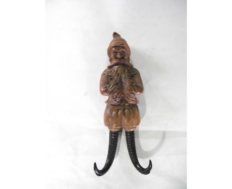 A Black Forest type two divisional wall hanging coat/cap rack of carved timber showing a study of Noel presented with flowing