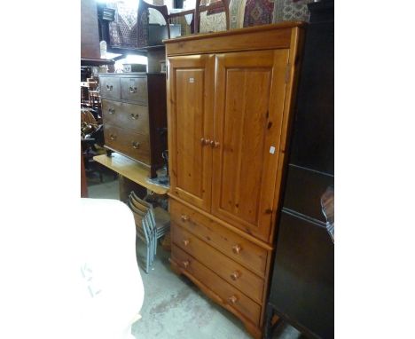 A modern stripped pine dwarf robe, the upper section enclosed by a pair of rectangular fielded panelled doors with hanging ra