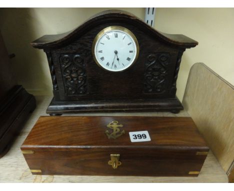 An Edwardian oak mantle clock, the shaped case with carved detail with convex enamel dial and 8 day time piece together with 
