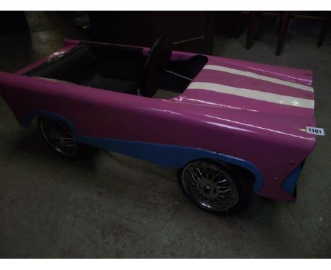 A vintage childs pedal car in the form of a Cadillac 