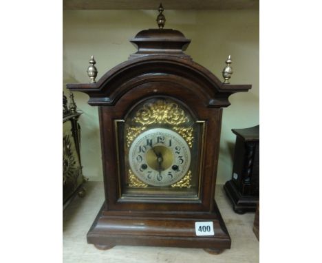 An Edwardian walnut bracket clock in the Georgian style with broken arched dial and applied spandrels with 8 day striking mov