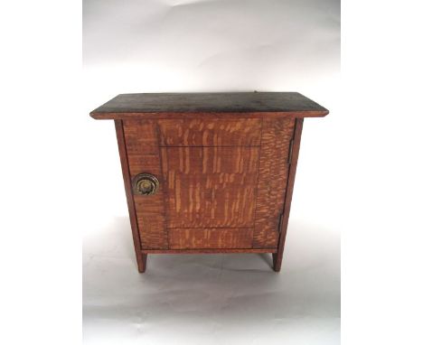 A small late 19th/early 20th century wall hanging cabinet, crafted principally in cherry wood with a panelled door and applie