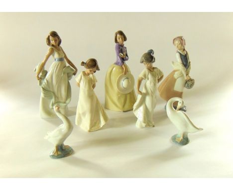 A collection of Nao figures comprising a girl with bird in her hand holding a hat, a girl carrying a basket, two little girls