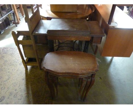 A vintage Singer treadle sewing machine with a cast iron base, together with a graduated nest of three occasional tables rais