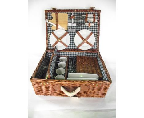 A good quality contemporary wicker picnic hamper, the lined interior containing plates, cutlery, cheese board, further condim