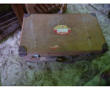 A vintage tan leather suitcase with reinforced corners, brass locks and brass studded detail