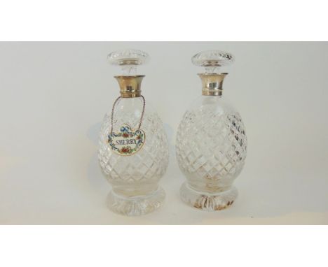 A pair of silver-mounted cut-glass decanters, Hukin & Heath Ltd, Birmingham, 1935, each ovoid body on a spreading foot, with 
