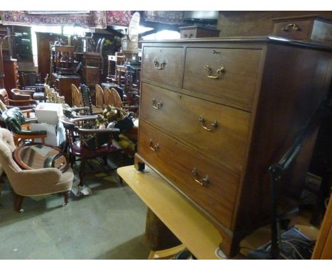 An Edwardian mahogany dressing chest of two long and two short deep drawers, raised on bracket shaped supports