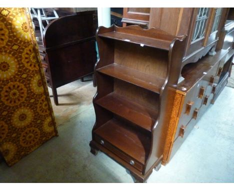 A small reproduction freestanding waterfall style bookcase with fixed shelves over a long drawer on ogee bracket shaped suppo