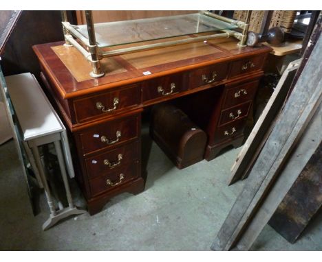 A reproduction mahogany veneered kneehole twin pedestal writing desk with triple inset leather top over an arrangement of nin