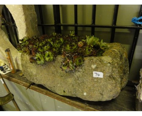 A small weathered rough hewn natural stone trough of rectangular form, planted with cacti