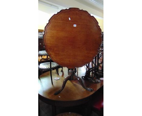 A Georgian mahogany pie-crust table with bird cage action raised on a turned and fluted column and good tripod base with carv