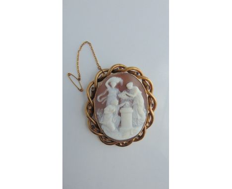A cameo brooch, the central oval cameo carved with three figures, in a gold-plated intertwining border, with safety chain