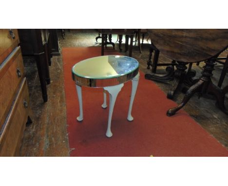 A vintage occasional table, the oval top with mirror plate, raised on four painted pad feet