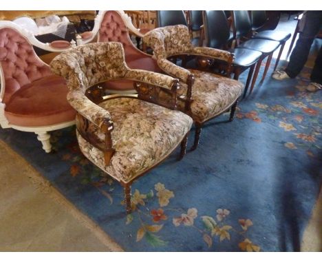 A pair of inlaid Edwardian low tub chairs with floral patterned upholstered seats, swept button backs and arm rests, with sha