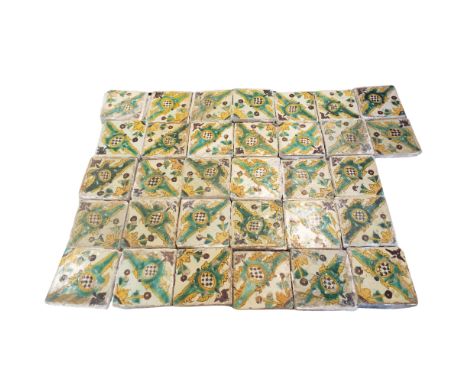 A collection of thirty four Catalonian tiles, circa 1740, painted with a stylised floral and geometrical pattern in green, go