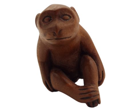 A Japanese carved wood netsuke of a monkey, Meiji period, height 4cm, width 3cm, depth 3.5cm.