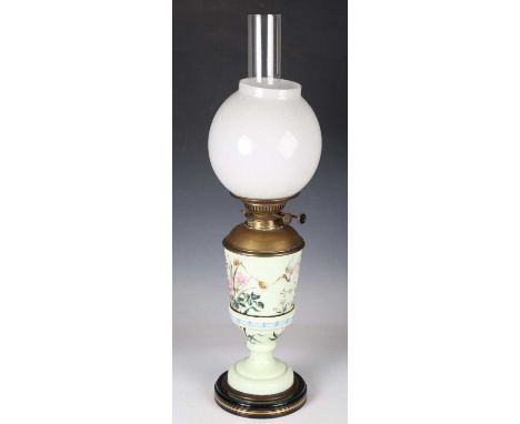 A late Victorian Aesthetic Movement pale green opaque glass oil lamp, enamelled with flowers and a bird, height to burner 40c