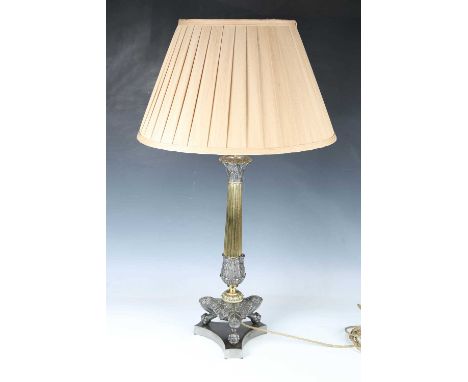 A Regency steel and gilt brass table lamp, converted to electricity, the reeded stem raised on tripod feet and a triform base