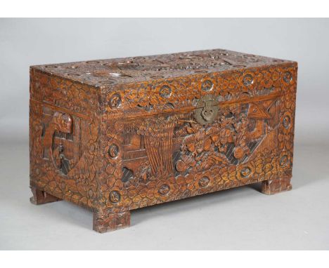 An early 20th century Chinese camphor trunk, the hinged top and front carved with battle scenes, height 57cm, width 101cm, de