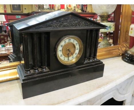 A Victorian black slate mantel clock of architectural form, central Roman dial, flanked by pillars
