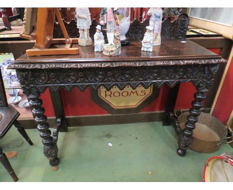A Victorian carved oak hall table with bobbin turned legs, 104cm long
