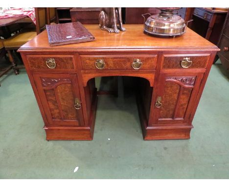 An Art Nouveau walnut twin pedestal desk with three drawers over two cupboards on a plinth base, 79 x 117 x 59cm