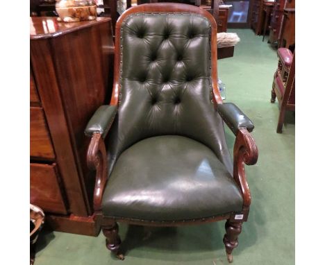 A Victorian mahogany button back armchair with green leather upholstery, scrolled arms 