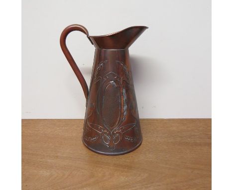 An Art Nouveau copper jug with embossed decoration 