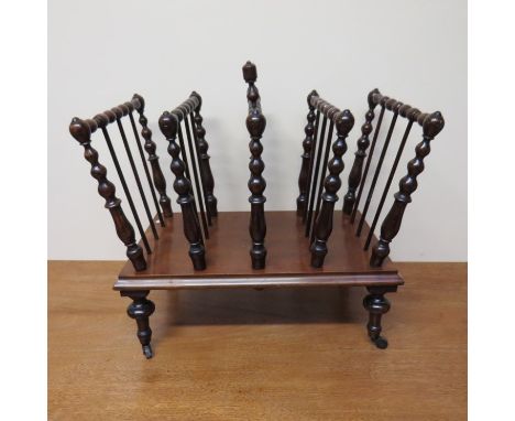 A Victorian Canterbury bobbin turned decoration, turned legs to ceramic castors, 57cm long