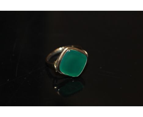 A YELLOW METAL RING STAMPED 333 SET WITH A LARGE JADE GREEN  STONE