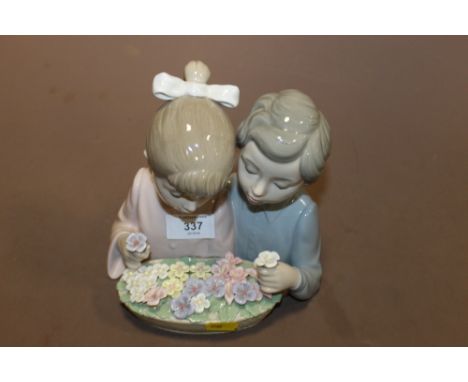 A LARGE NAO FIGURE OF A BOY + A GIRL PICKING FLOWERS