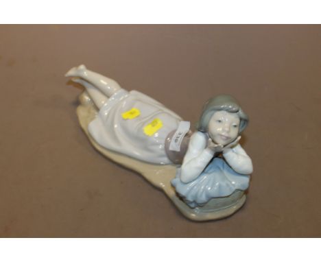 A LARGE NAO FIGURINE OF A GIRL LYING DOWN