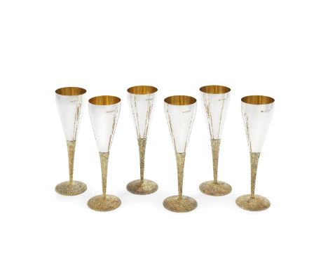 STUART DEVLIN: six silver and silver-gilt champagne flutesLondon 1973The tapering bowls with spot hammered surface, gilt inte